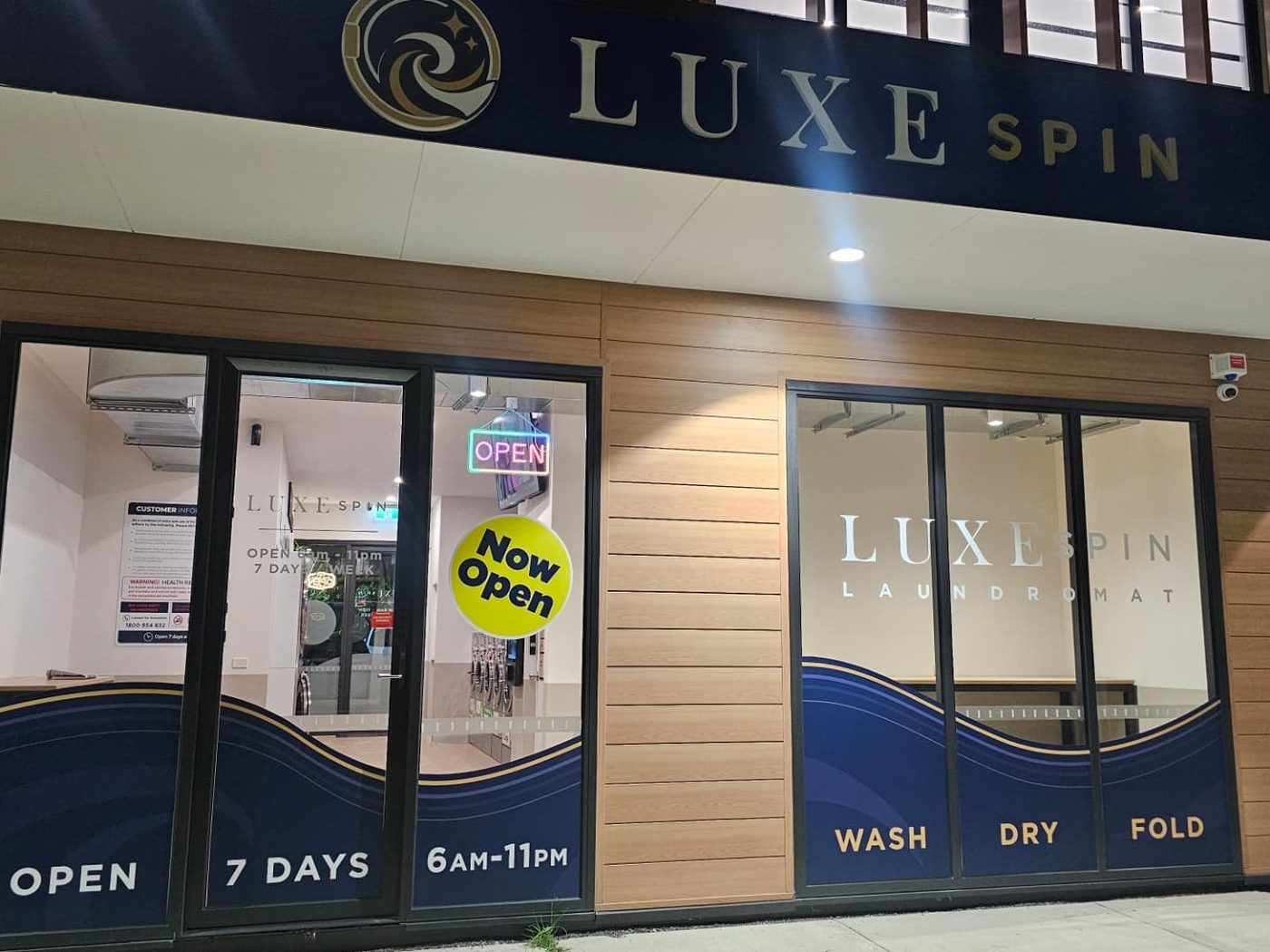 The LuxeSpin laundromat shopfront in Officer, Victoria, with signage and Open 7 Days 6am–11pm window graphics